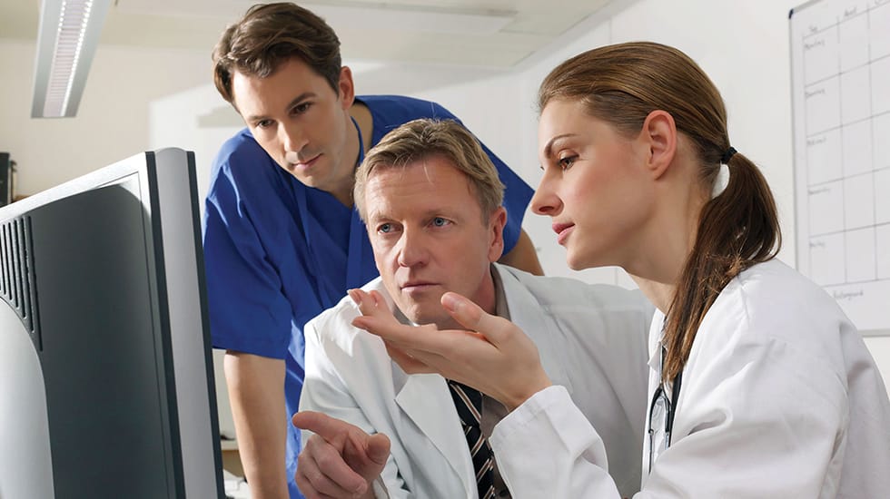 Download image (.jpg) (opens in a new window) Two doctors reviewing mammogram case